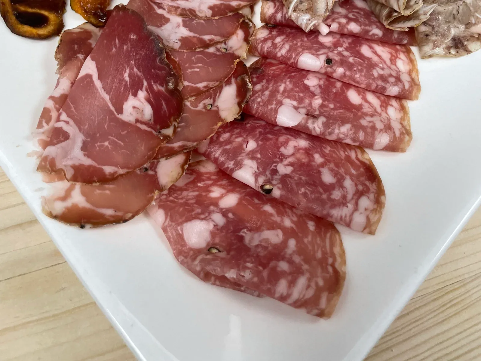 Assorted regional salumi arranged on a white platter at Davanti