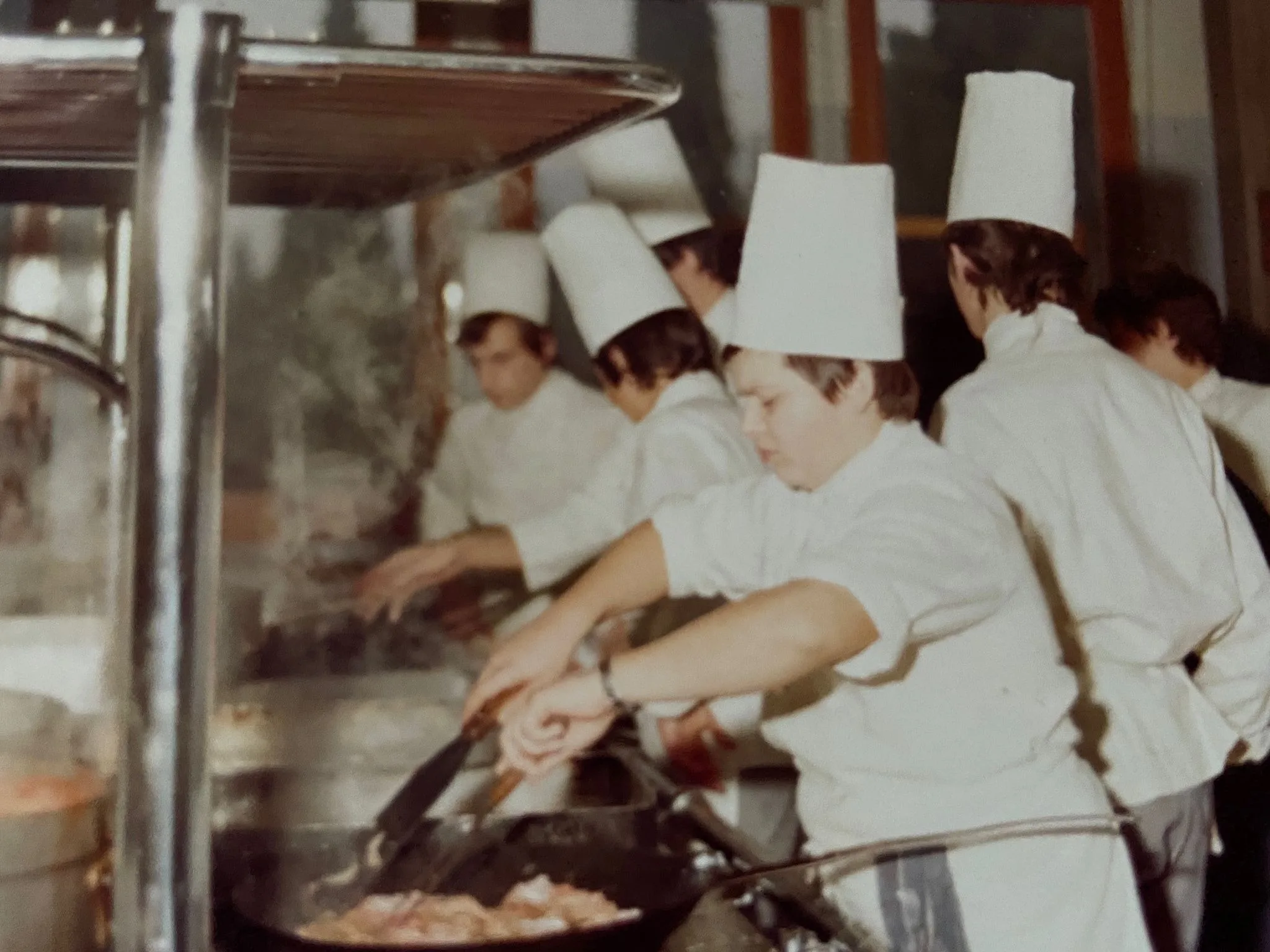 Chef Roberto Crescini cooking in an archival kitchen photograph
