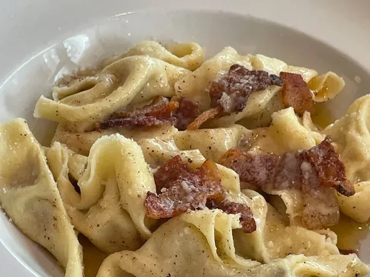 Casoncelli alla Bresciana filled pasta with prosciutto in a white bowl at Davanti