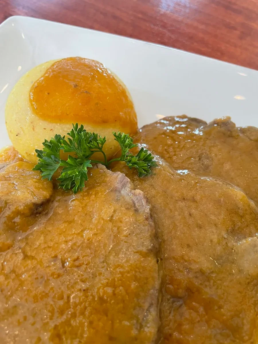 Slices of Manzo all’Olio in a golden sauce served with polenta at Davanti