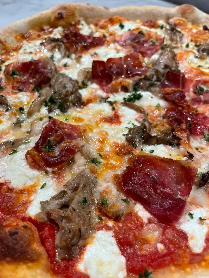 Hero archive view of Pizza con Formaggio di Capra, Speck e Funghi Pleurotus plated at Davanti