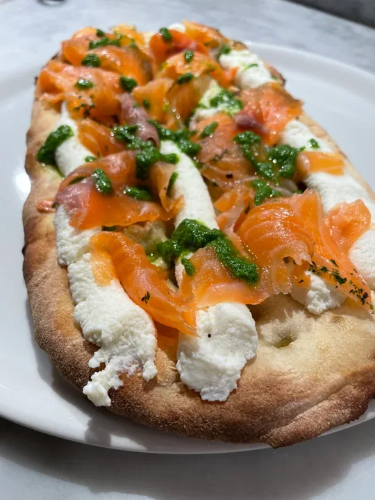 Hero archive view of Pinsa Romana con Salmone Marinato, Ricotta e Pesto di Rucola plated at Davanti