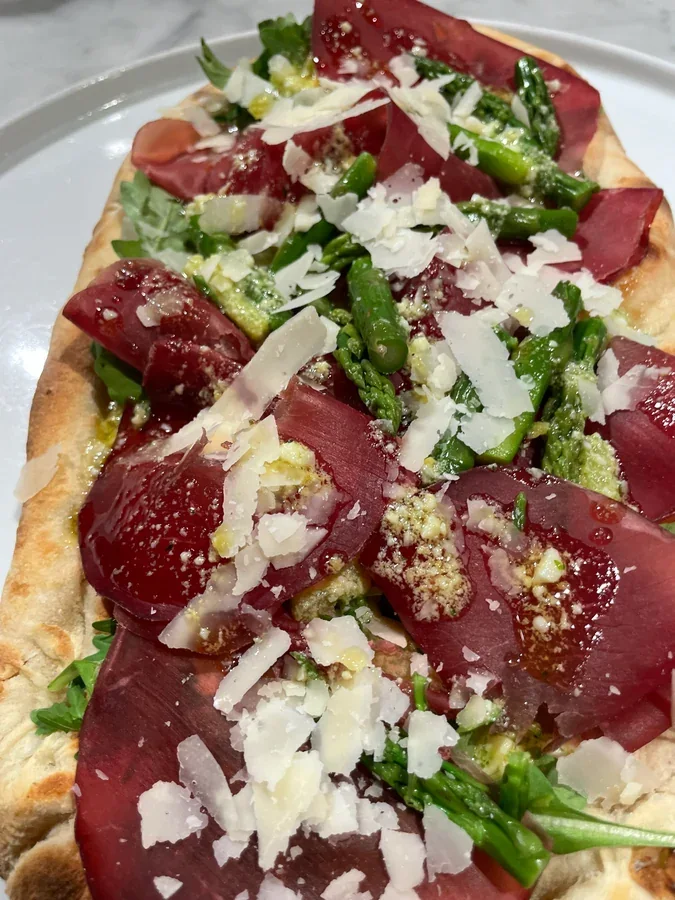 Hero archive view of Pinsa Romana con Bresaola, Asparagi in Salsa Mimosa e Parmigiano plated at Davanti