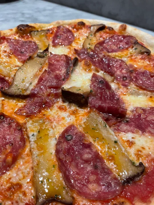 Hero archive view of Pizza con Funghi Cardoncelli, Caciotta al Tartufo e Salame Napoletano plated at Davanti