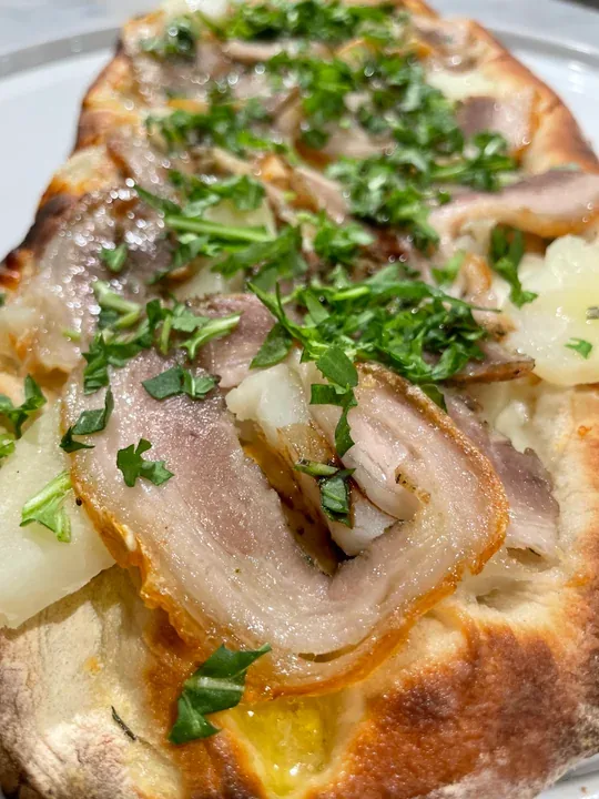 Hero archive view of Pinsa con Porchetta, Patate e Rucola plated at Davanti