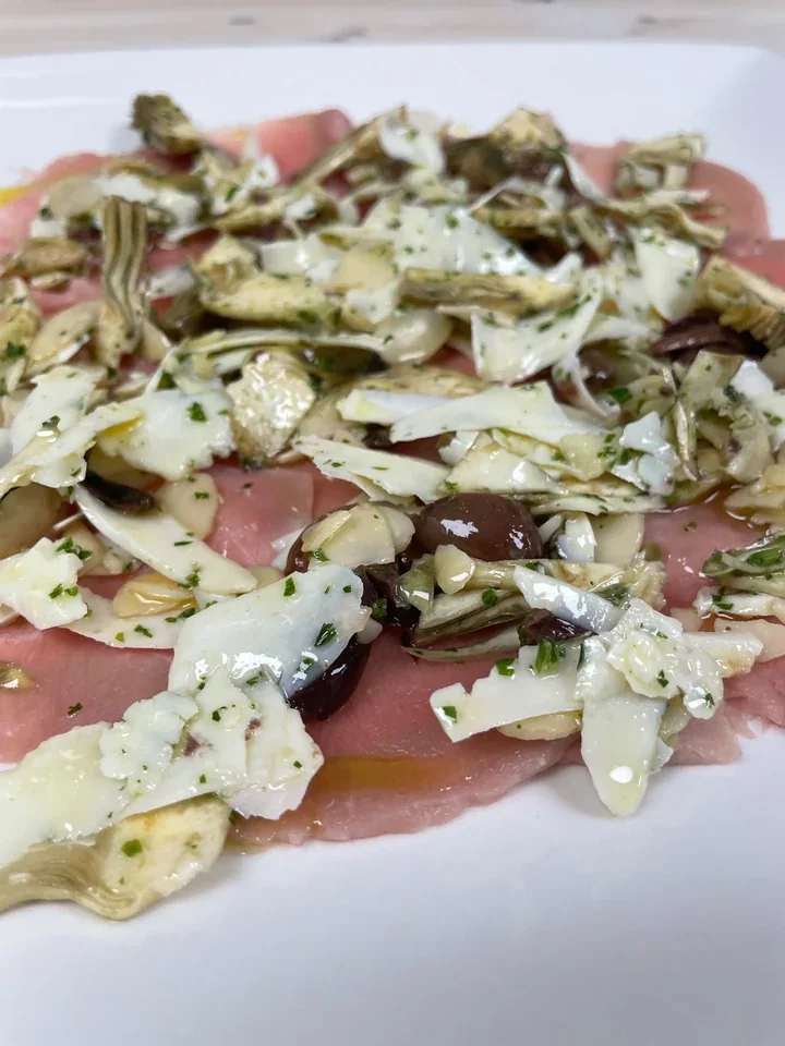 Archive view of Carpaccio di Vitello con Carciofi, Olive, Mandorle e Ricotta Stagionata plated at Davanti