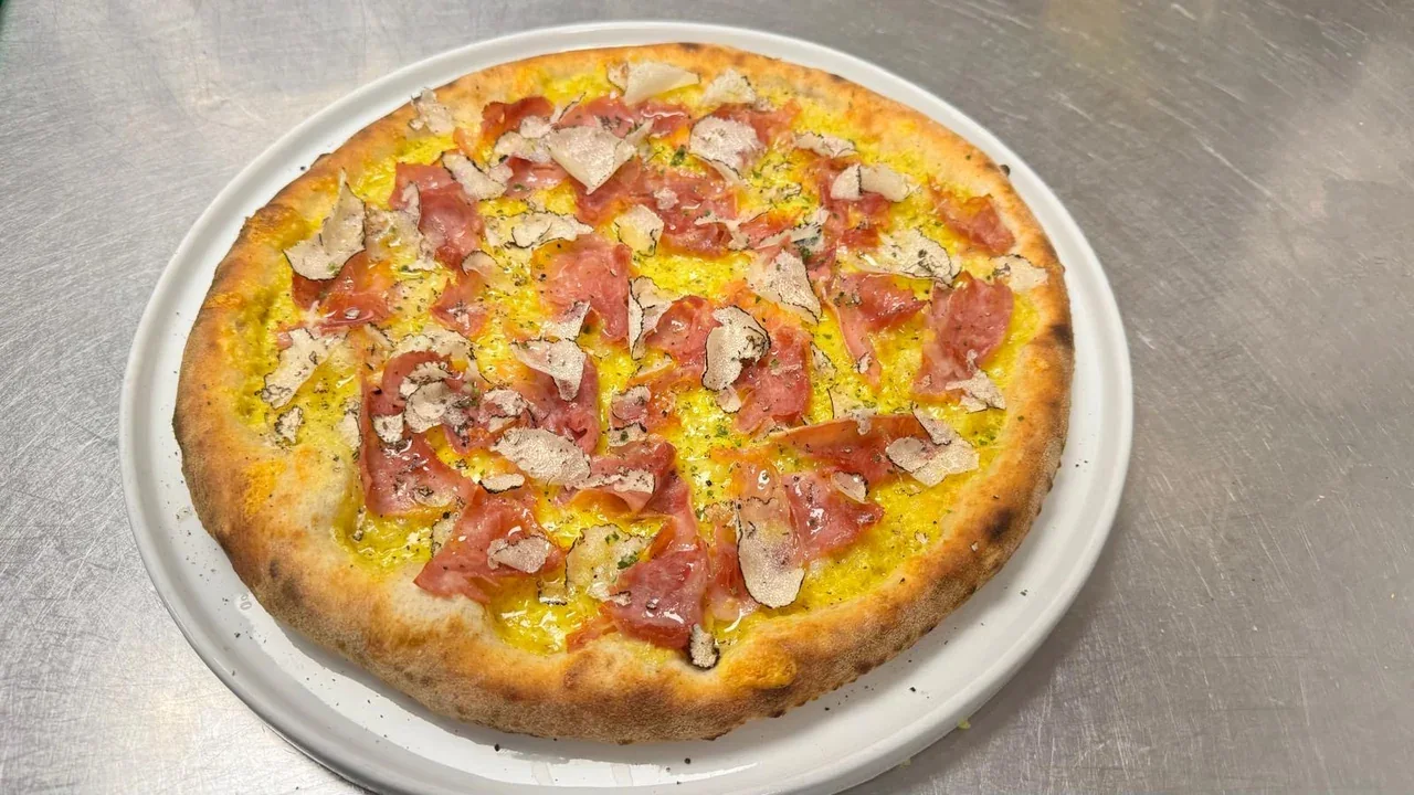 Archive view of Pizza con Caciotta allo Zafferano, Prosciutto Cotto di Vignola e Tartufo Nero plated at Davanti