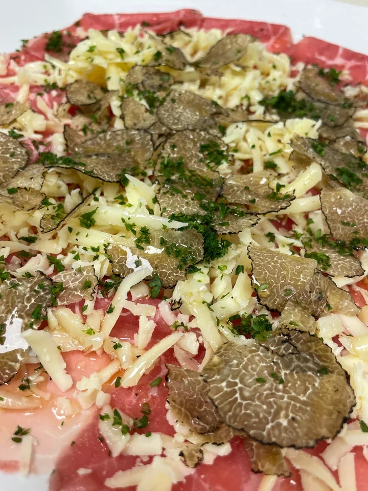 Archive view of Carpaccio di Manzo con Tartufo Nero Asiago e Olio di Nocciole plated at Davanti