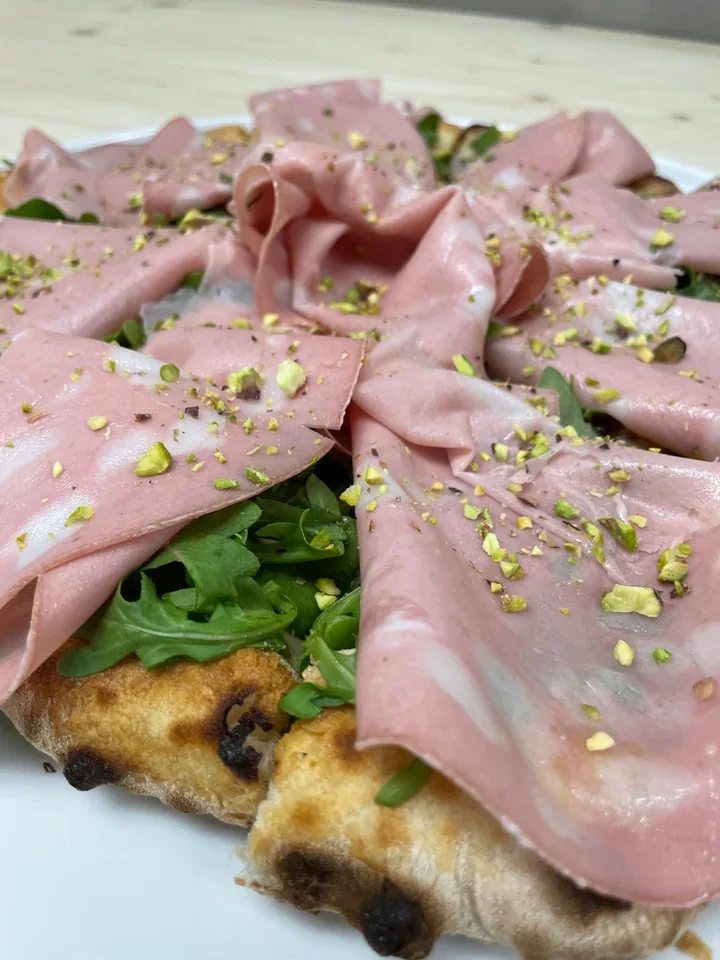 Archive view of Pizza con Mortadella, Squacquerone, Rucola e Pistacchio plated at Davanti