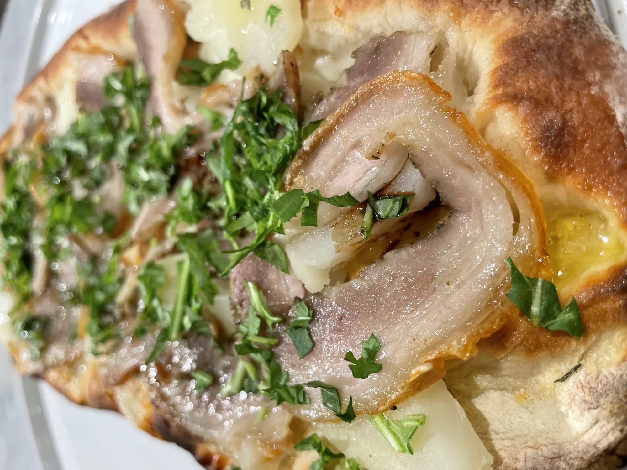 Davanti pinsa topped with roasted pork, potato, stracciatella, and arugula