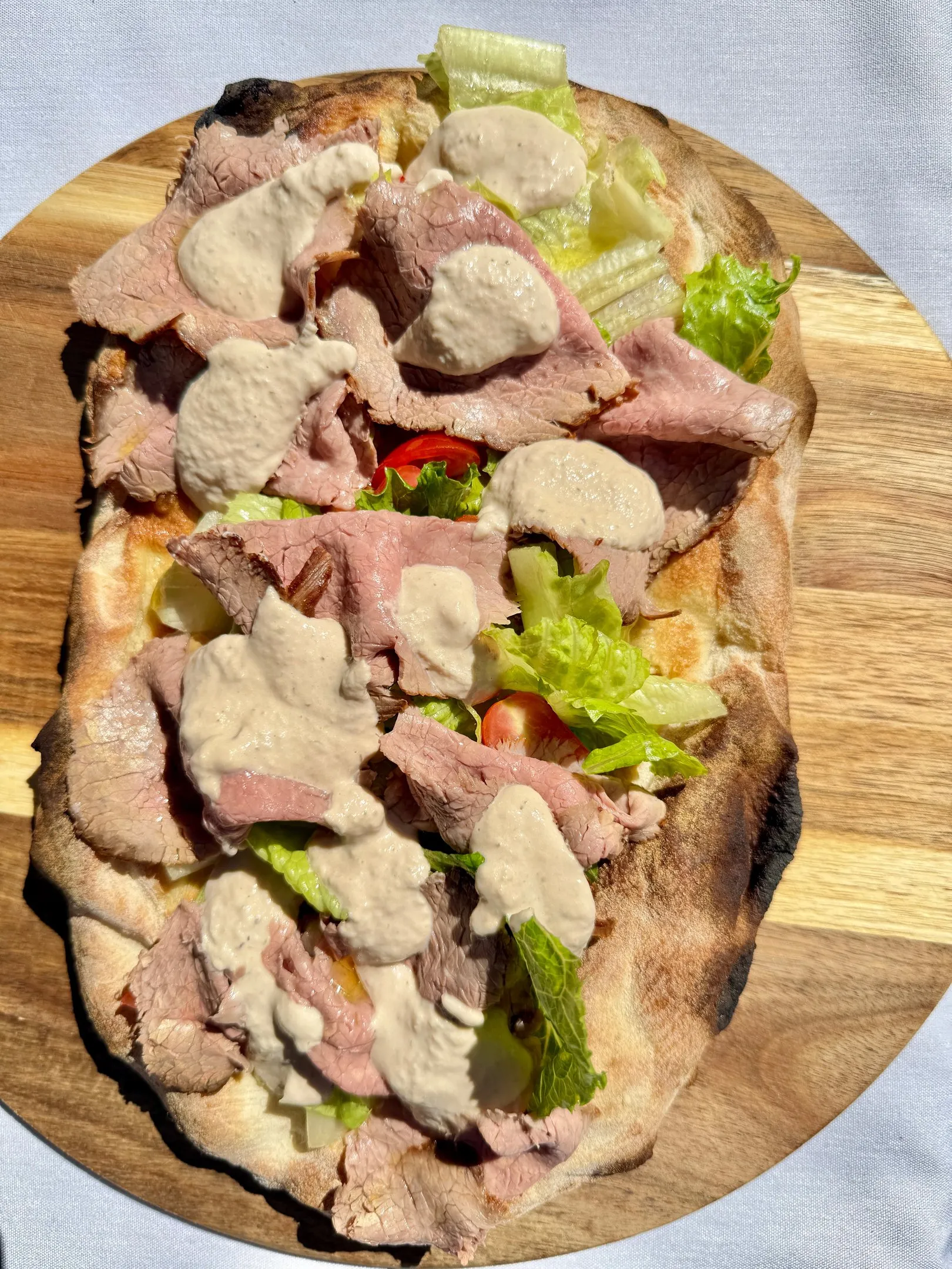 Davanti pinsa topped with roast beef, lettuce, tomato, and sauce