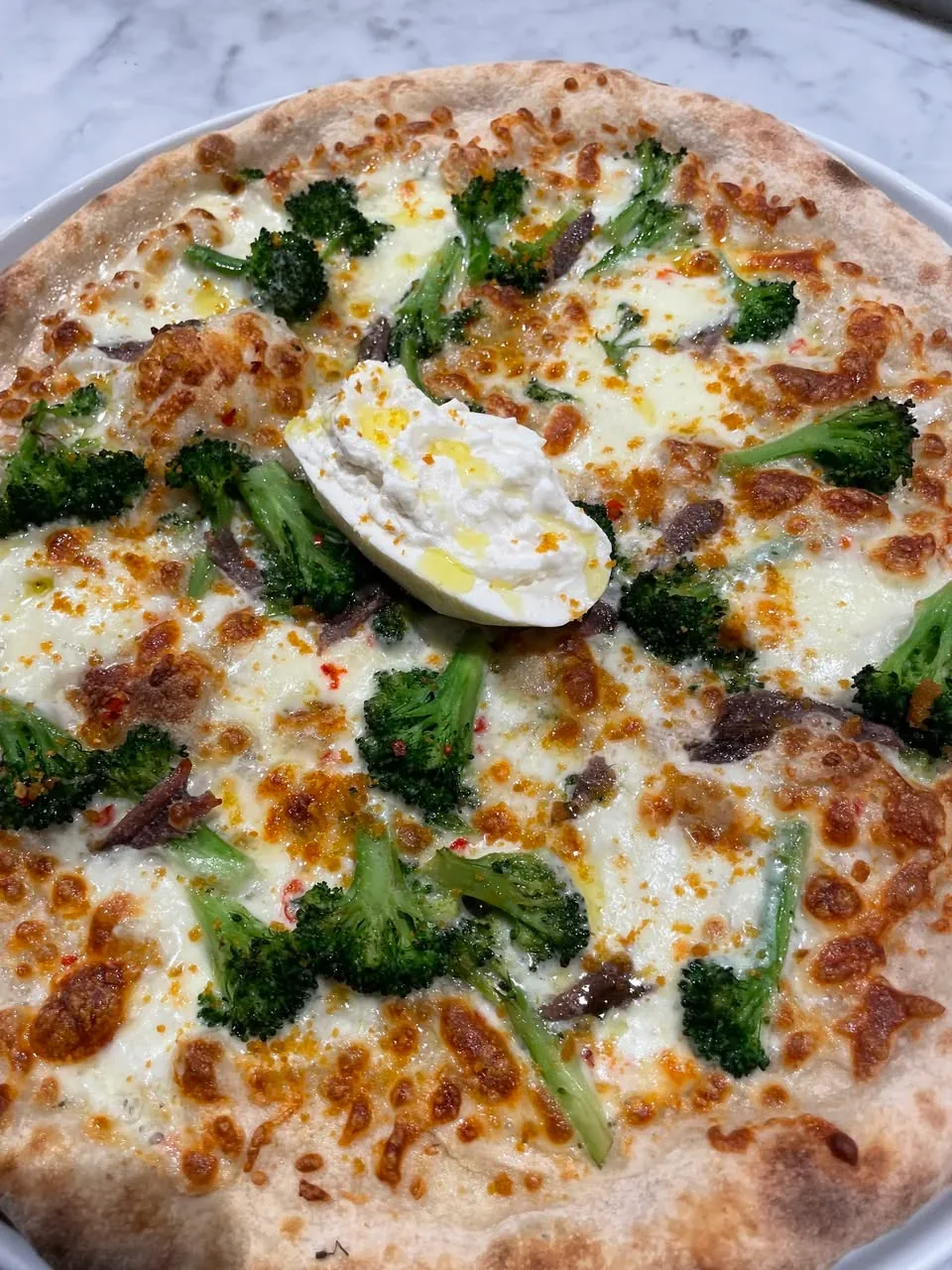 Pizza topped with broccoletti, burrata and Mediterranean anchovies at Davanti