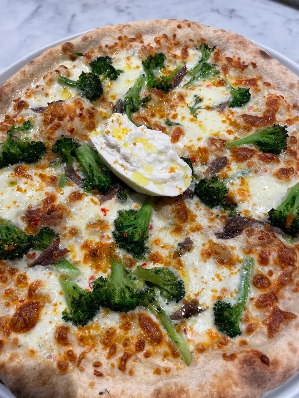 Pizza topped with broccoletti, burrata and Mediterranean anchovies at Davanti