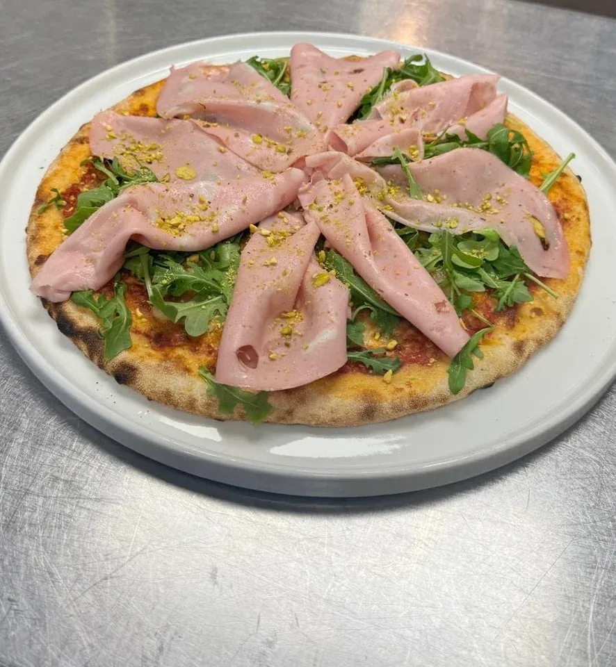 Pizza with goat cheese, mortadella, arugula, and pistachios at Davanti
